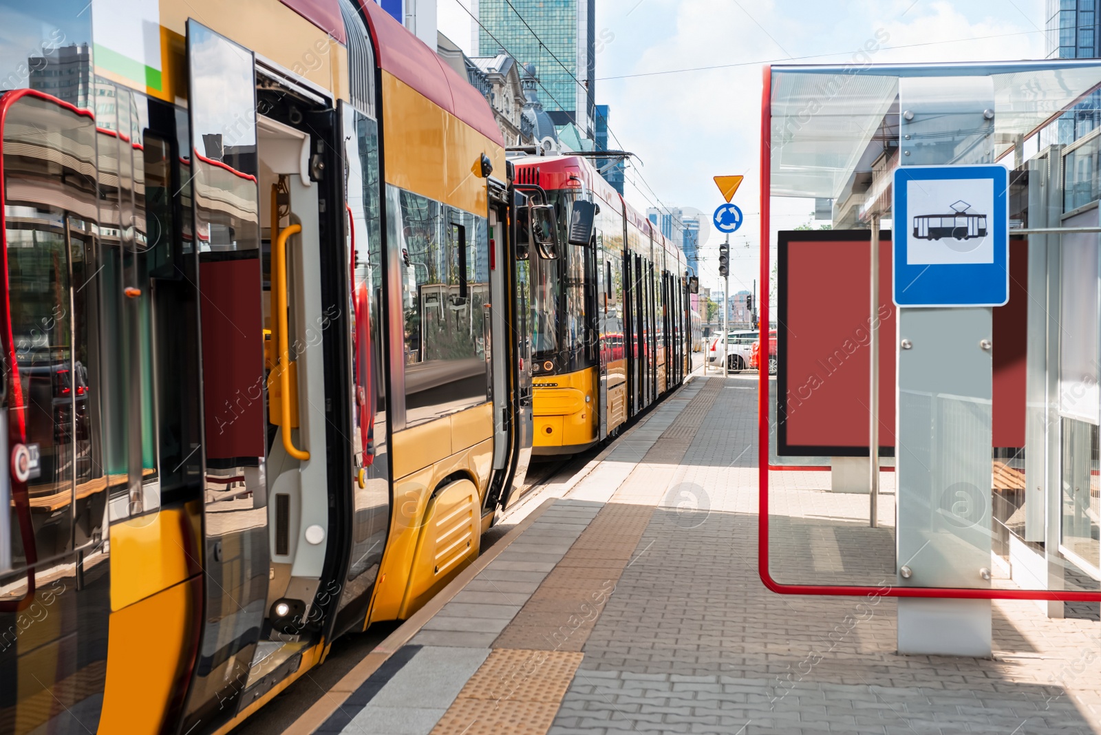 Photo of Modern streetcars near tram stop on sunny day. Public transport