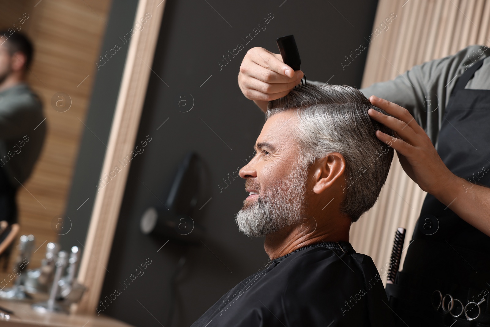 Photo of Hair styling. Professional hairdresser working with client in barbershop, closeup