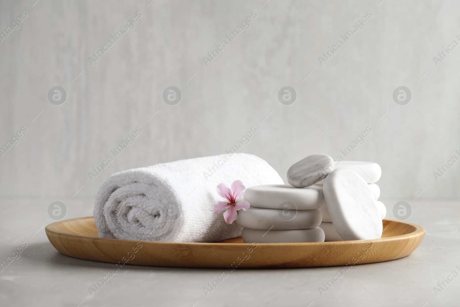 Photo of Spa stones, towel and fresia flower on light table