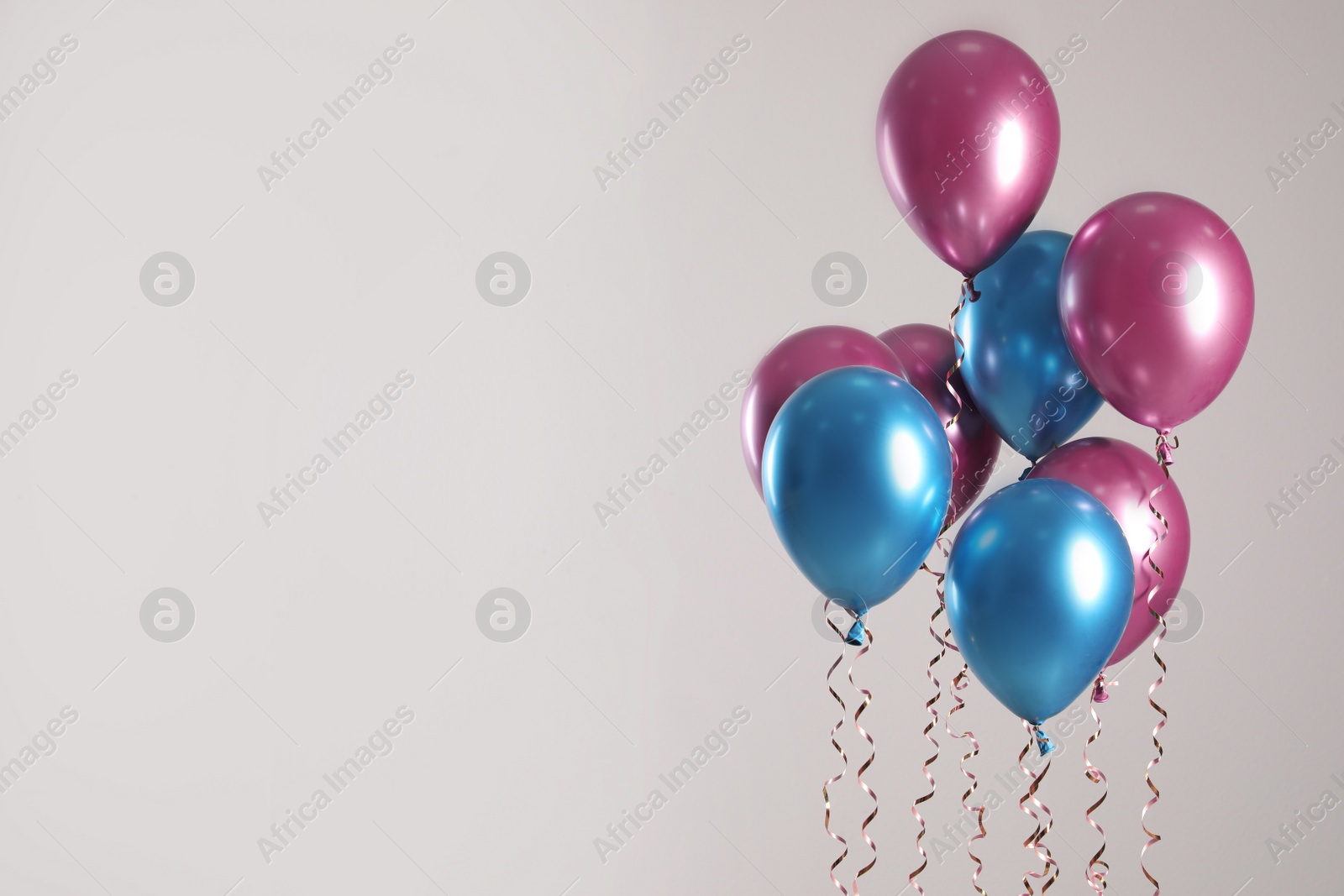 Photo of Bright balloons on light background. Space for text