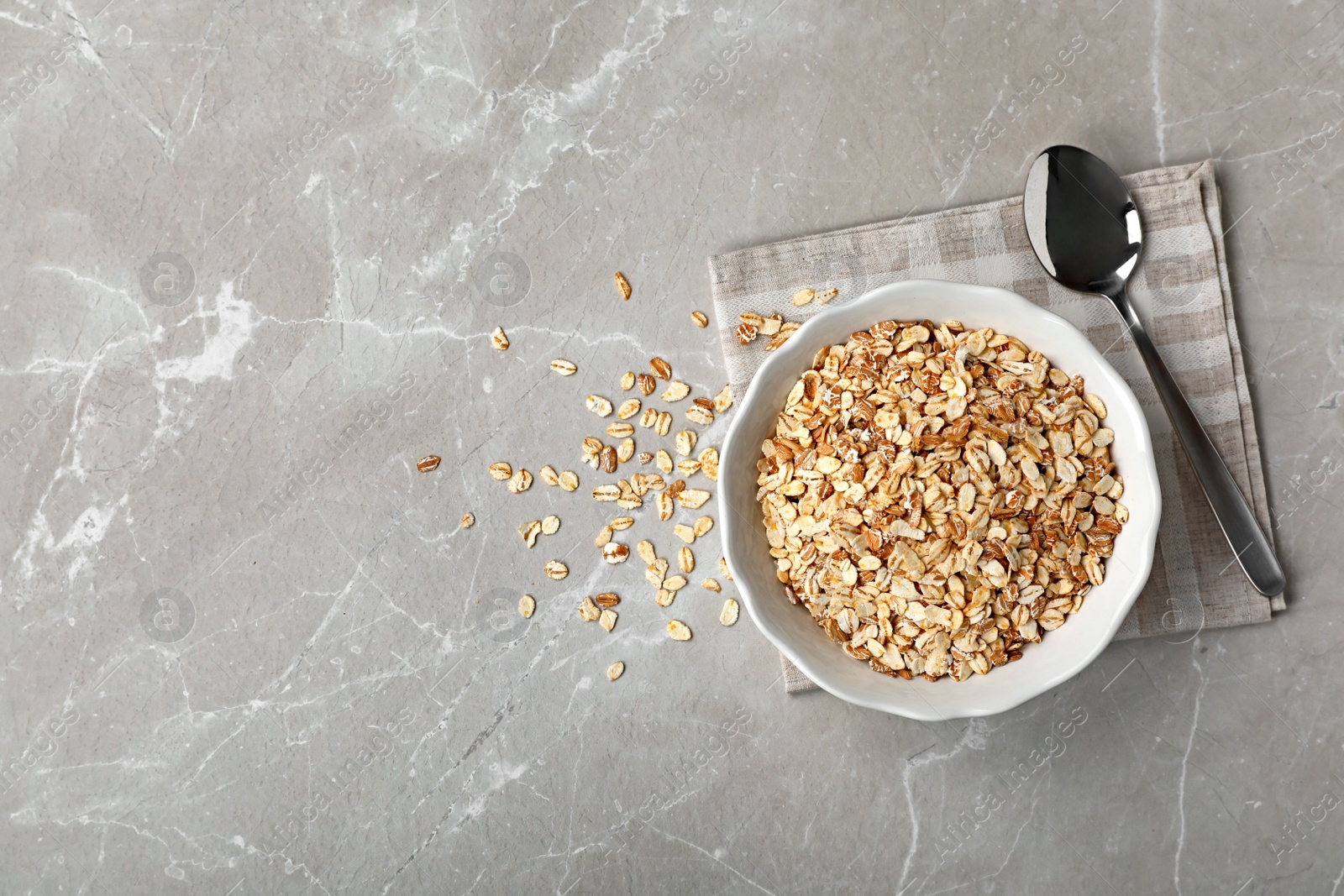 Photo of Bowl of rolled oat on light table, top view with space for text