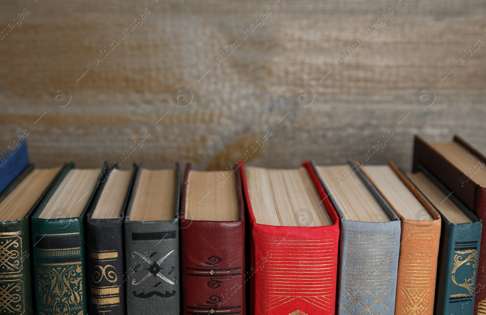 Photo of Stack of hardcover books on wooden background, closeup