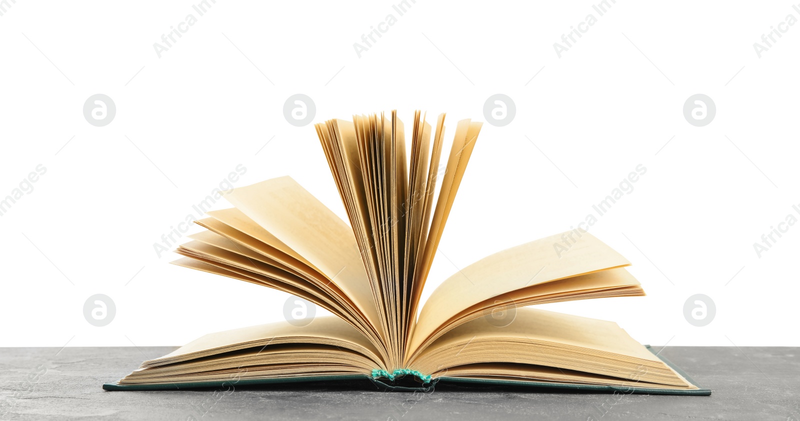 Photo of Open book on grey stone table against white background