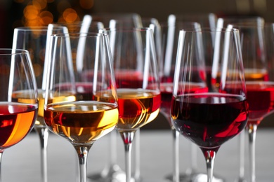 Glasses with different wines on blurred background, closeup