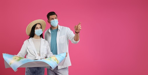 Couple of tourists in medical masks with map on pink background, space for text. Travelling during coronavirus pandemic