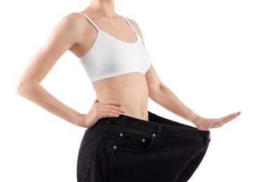 Photo of Young slim woman wearing oversized jeans on white background, closeup