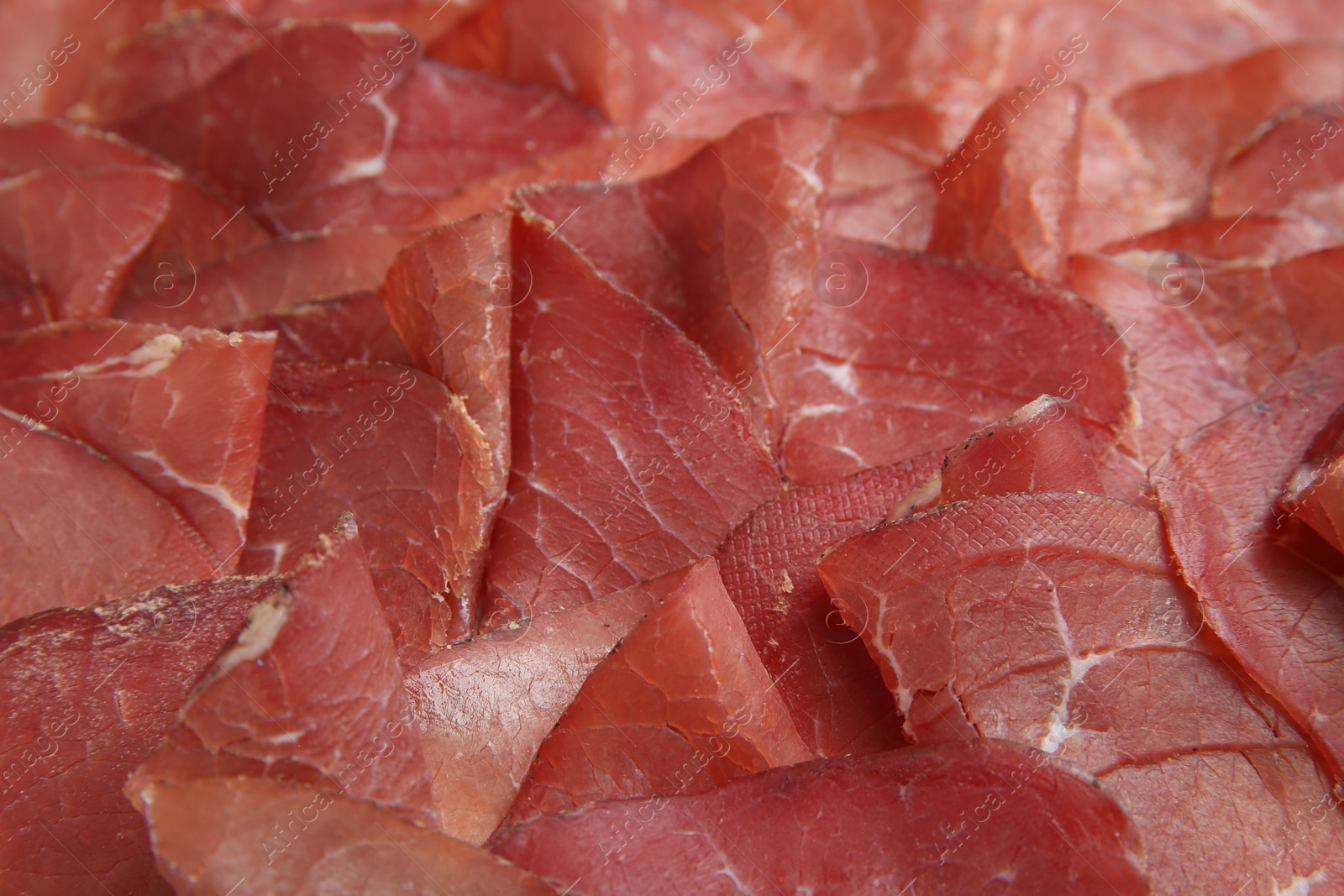 Photo of Slices of tasty bresaola as background, closeup