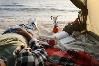 Man resting in camping tent near sea, closeup