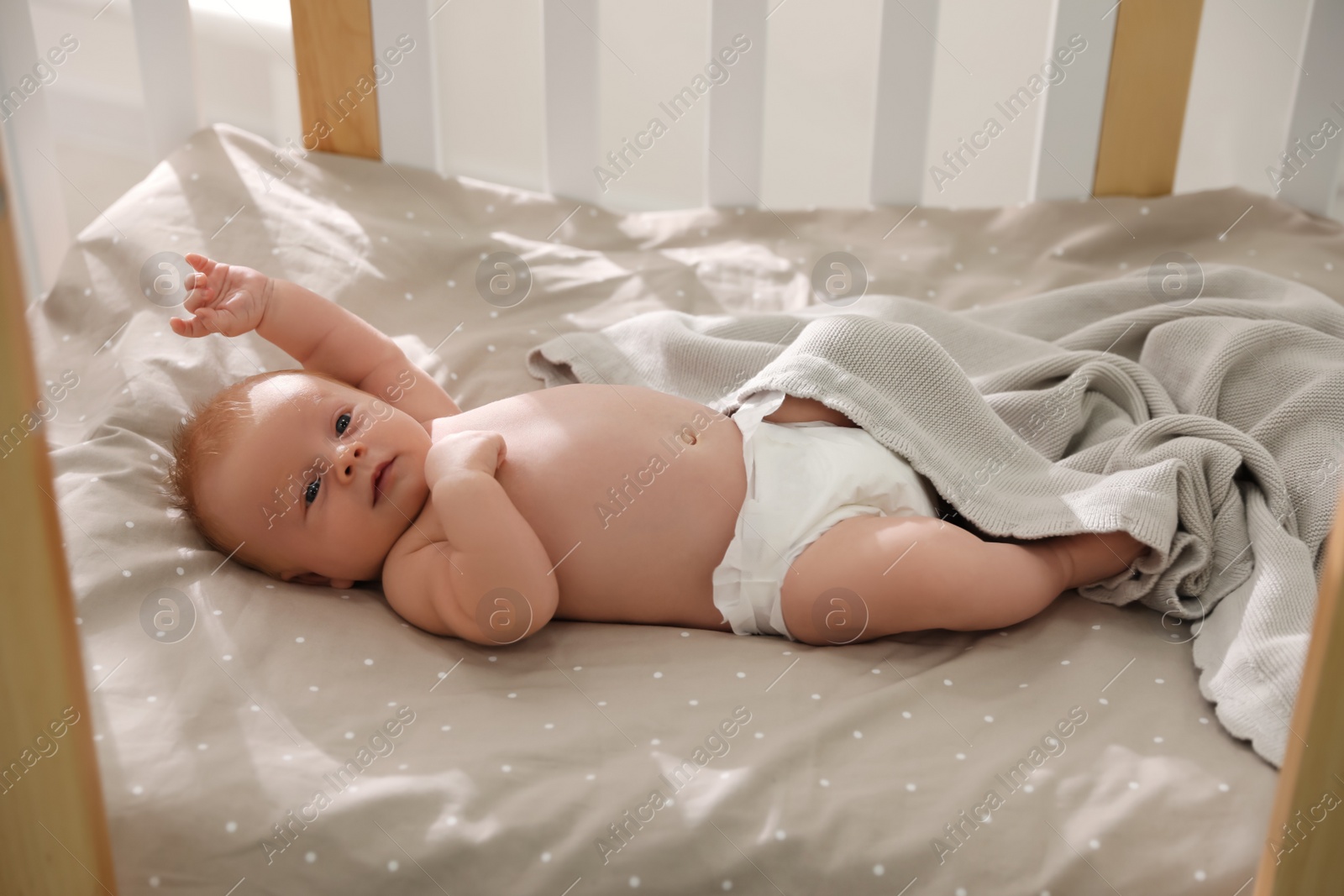 Photo of Cute little child lying in cot. Healthy baby