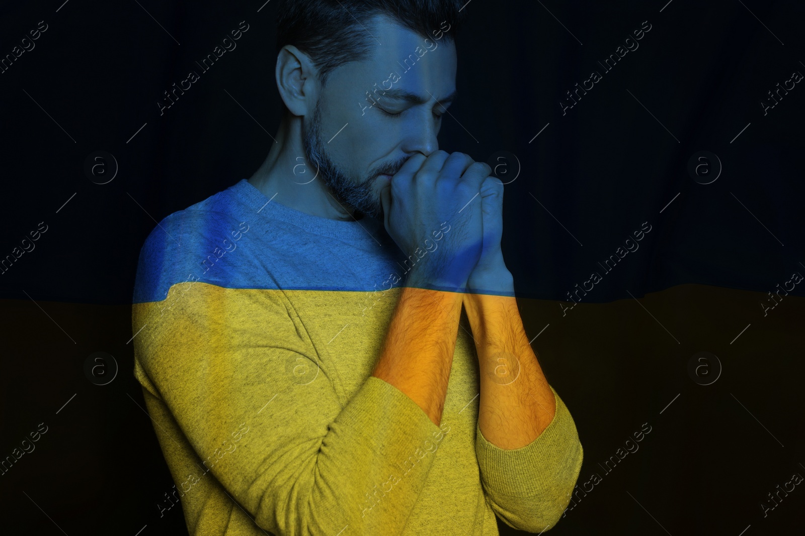 Image of Double exposure of national flag and man praying. Stop war in Ukraine