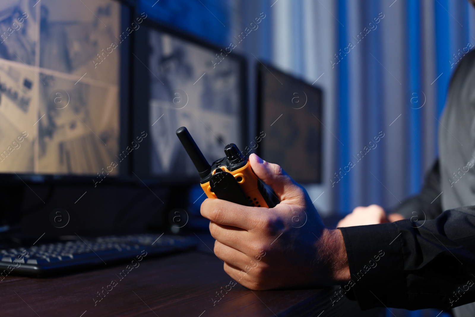 Photo of Male security guard with portable transmitter monitoring modern CCTV cameras indoors, closeup