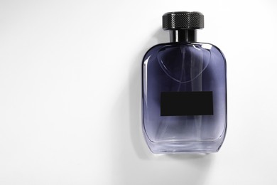 Luxury men`s perfume in bottle on white background, top view. Space for text