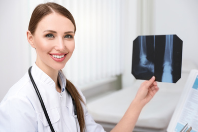 Photo of Professional orthopedist examining X-ray picture in her office