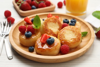 Photo of Delicious cottage cheese pancakes with fresh berries and honey on white wooden table