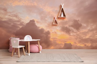 Image of Picturesque sky with clouds as wallpaper pattern. Baby room interior with table and chairs near wall