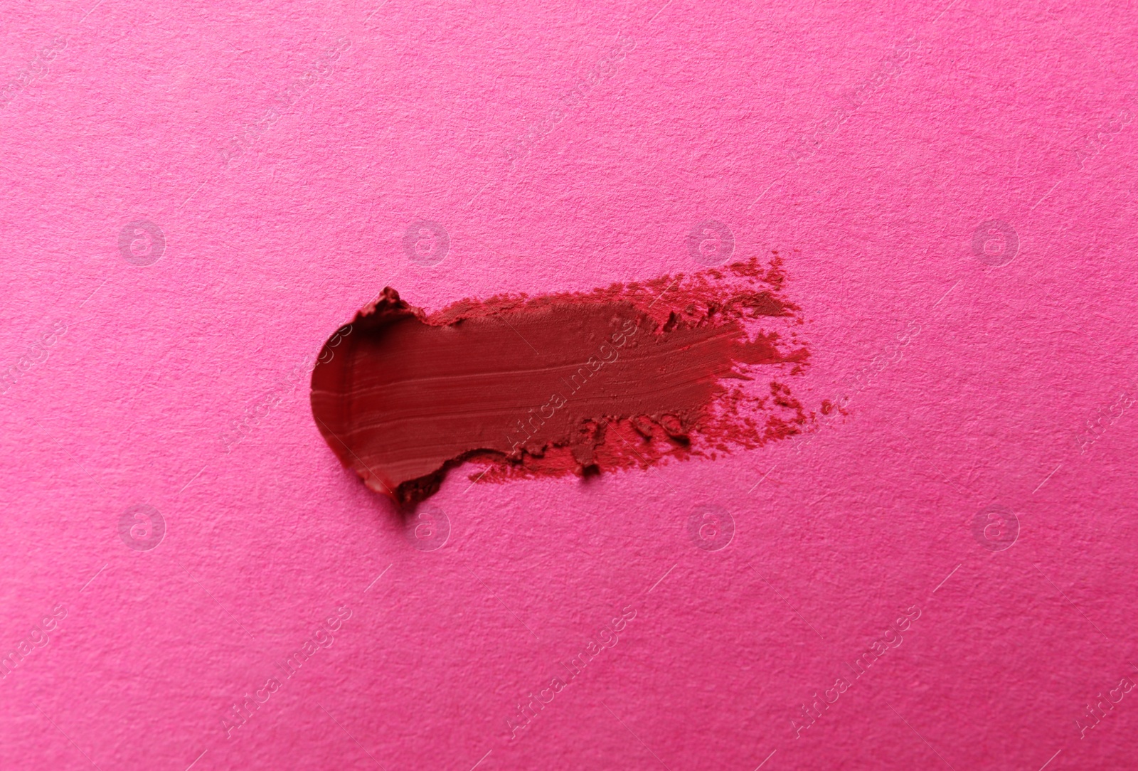 Photo of Smear of beautiful lipstick on pink background, top view