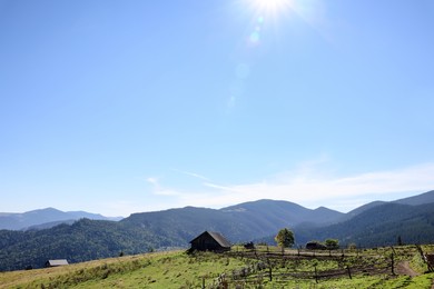 Photo of View of rural house in mountains on sunny morning. Space for text