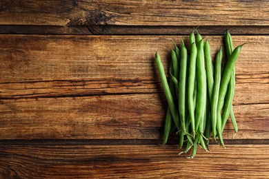 Fresh green beans on wooden table, flat lay. Space for text