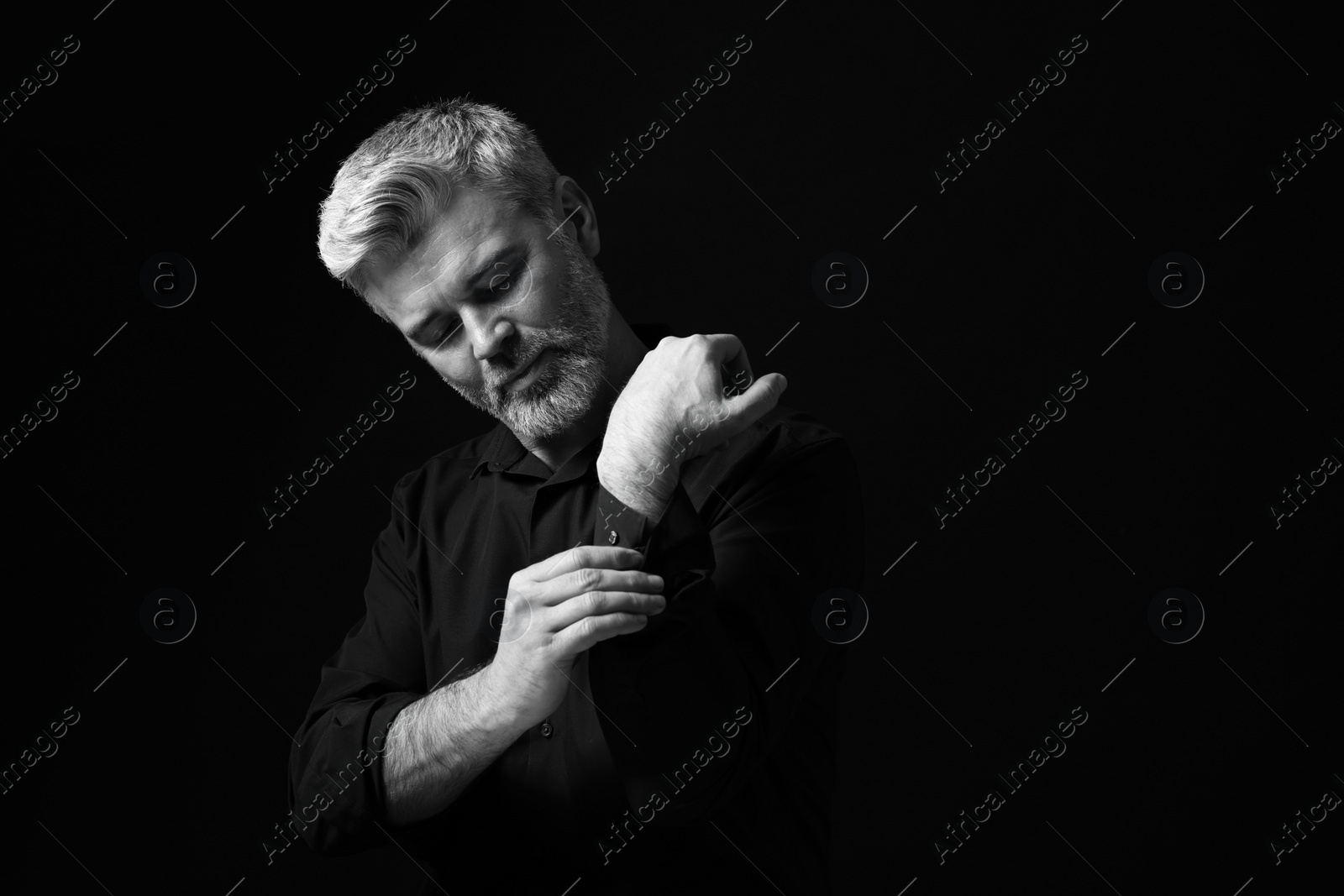 Photo of Portrait of handsome man on dark background. Black and white effect