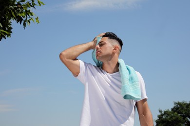 Man with towel suffering from heat stroke outdoors