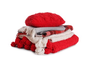 Photo of Stack of folded warm plaids with pillow on white background