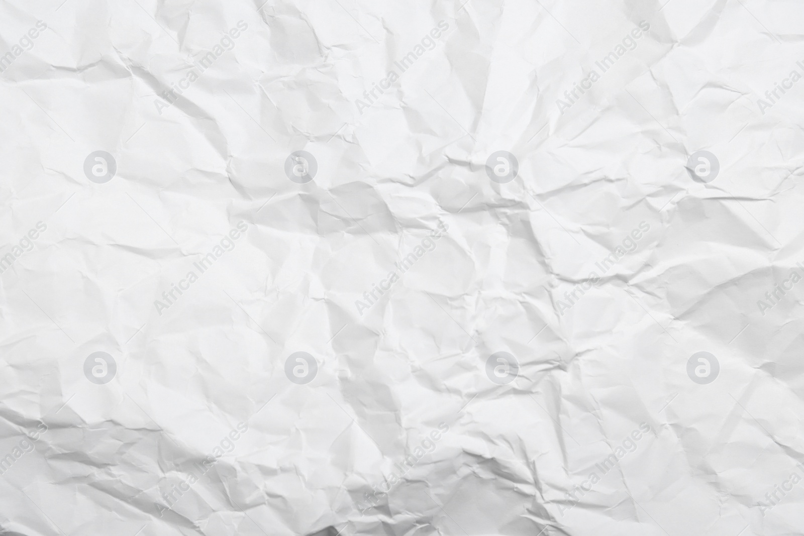 Photo of Sheet of white crumpled paper as background, closeup