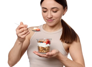 Happy woman eating tasty granola with fresh berries and yogurt on white background