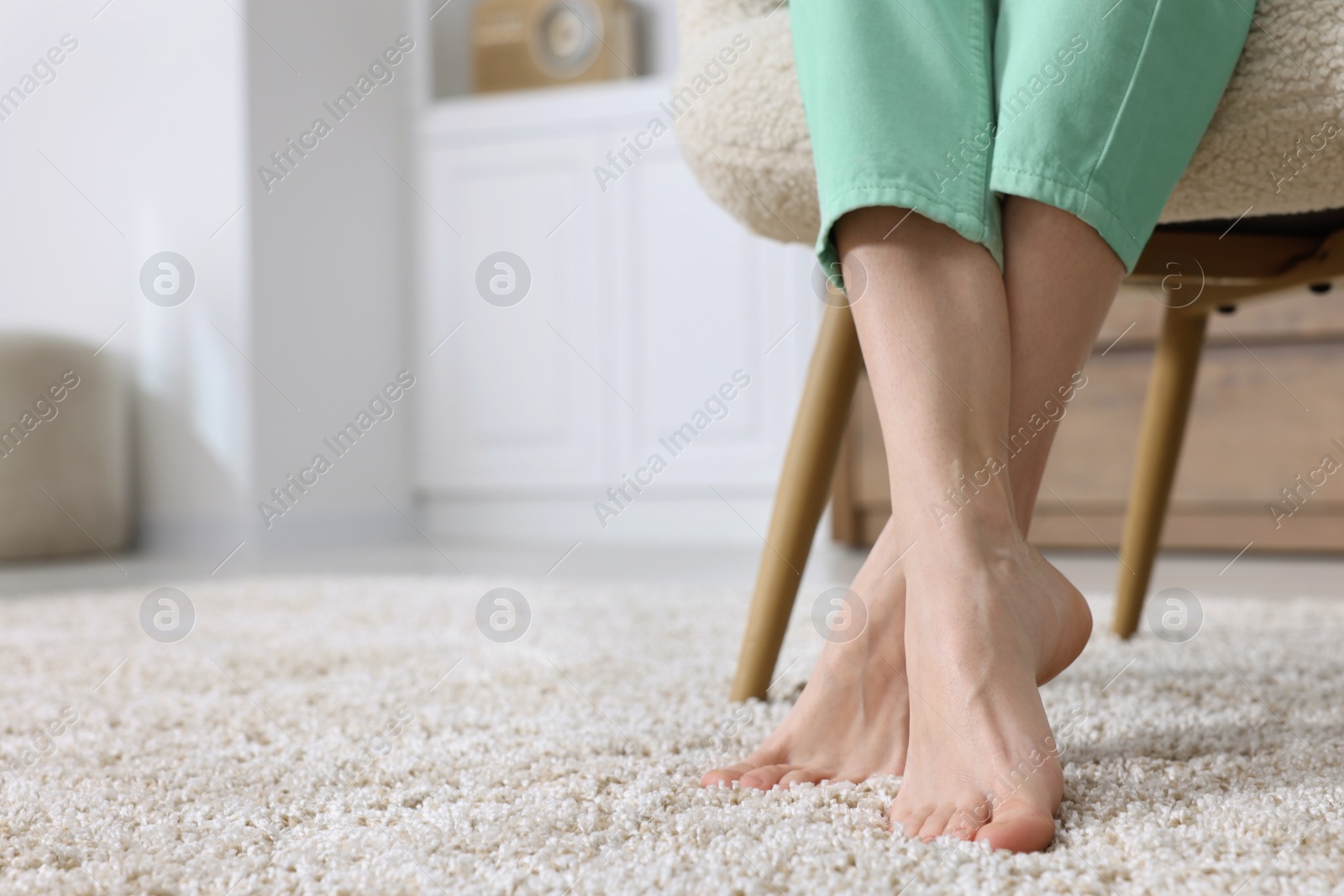 Photo of Woman on soft light brown carpet at home, closeup. Space for text