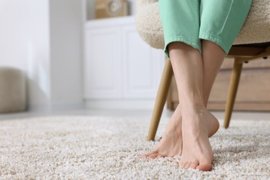 Woman on soft light brown carpet at home, closeup. Space for text