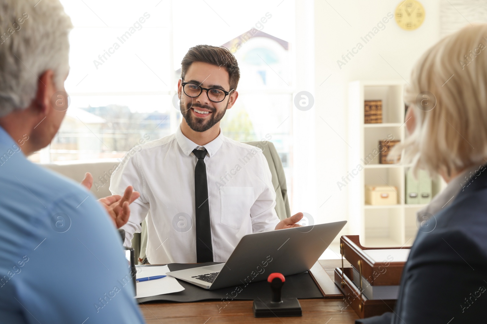 Photo of Male notary working with mature couple in office