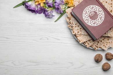 Photo of Flat lay composition with matzo and Torah on wooden background, space for text. Passover (Pesach) Seder