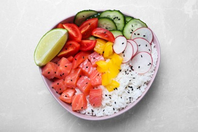 Photo of Delicious poke bowl with salmon, rice and vegetables on light grey table, top view