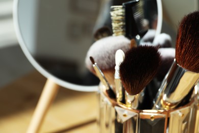 Photo of Set of professional brushes and mirror, closeup. Space for text