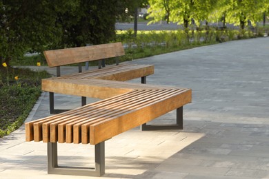 Photo of Wooden bench in city park on sunny morning