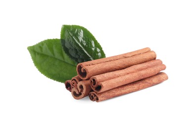 Aromatic cinnamon sticks and green leaves isolated on white