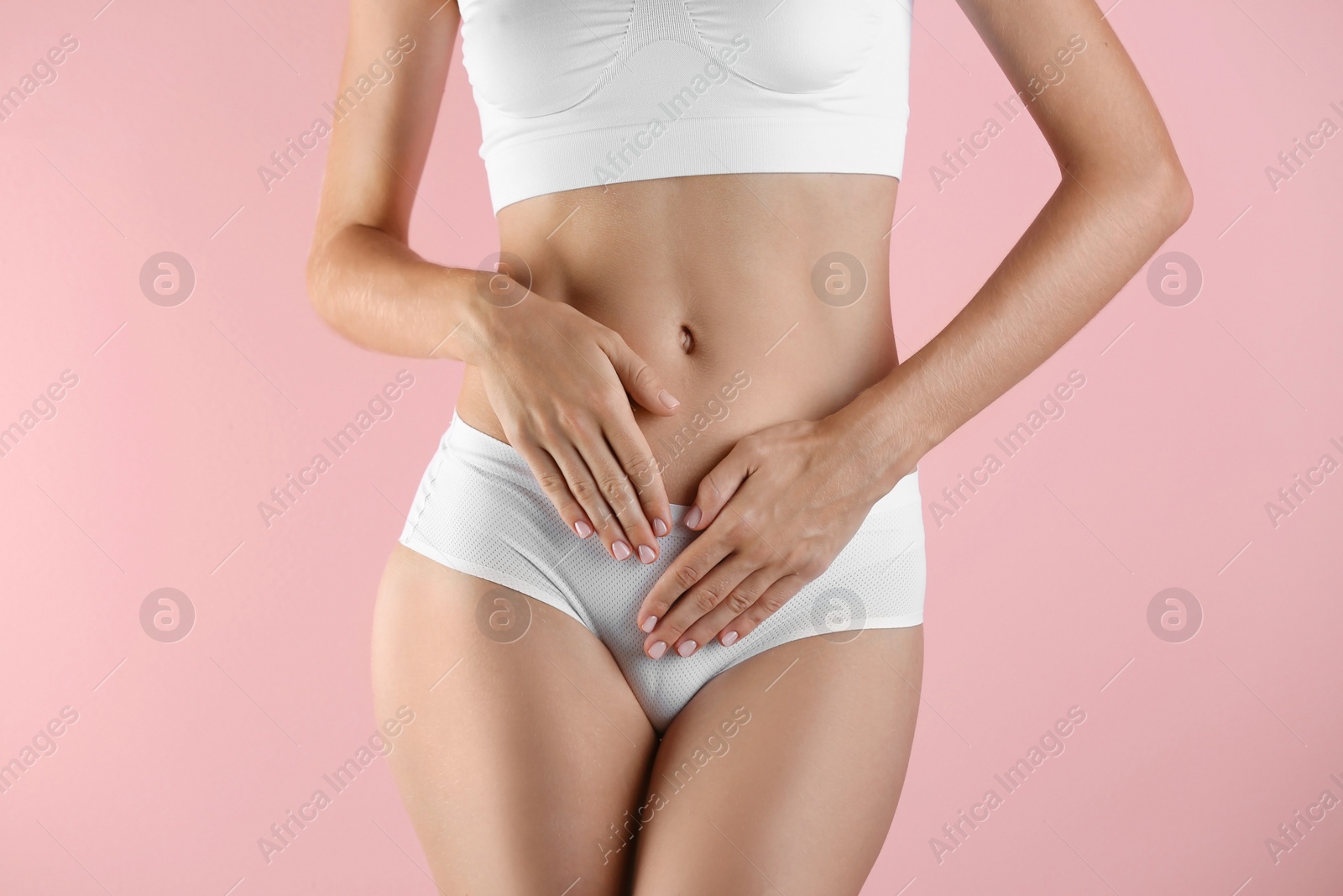 Photo of Young woman holding hands near panties on color background. Gynecology concept