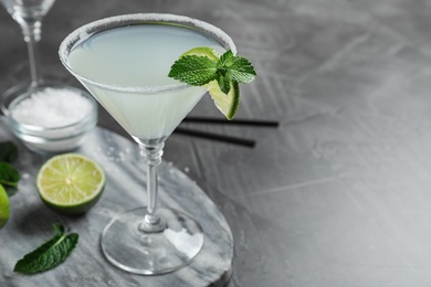 Photo of Delicious cocktail on grey table, closeup. Space for text