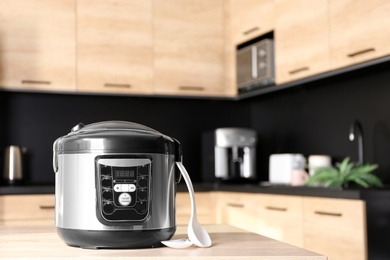 Photo of Modern multi cooker on table in kitchen, space for text