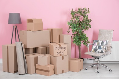 Photo of Cardboard boxes and household stuff in empty room. Moving day