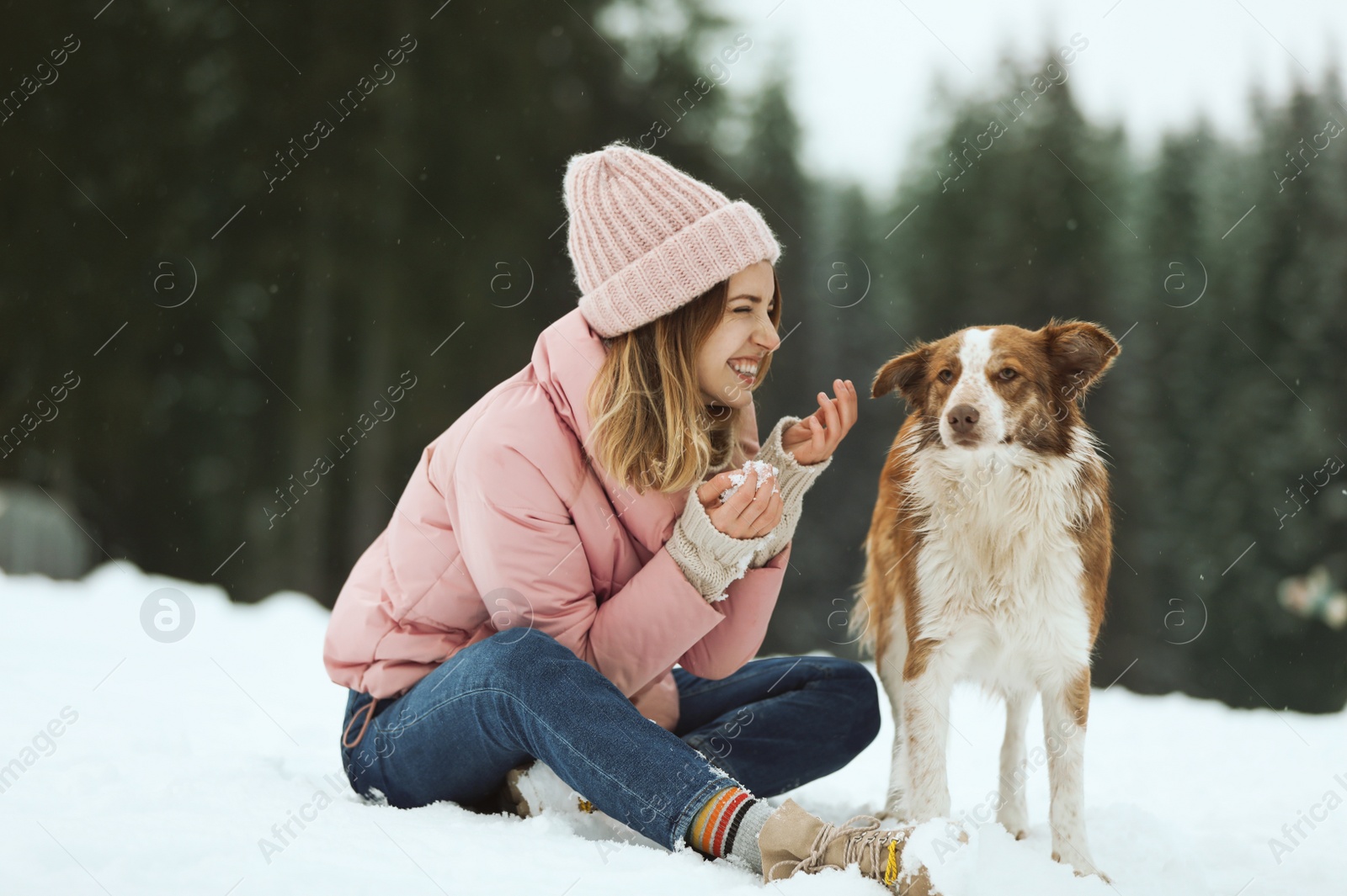 Photo of Young woman with dog near forest. Winter vacation