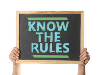 Woman holding chalkboard with phrase Know the rules on white background, closeup