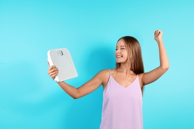 Photo of Slim woman with scale on color background. Healthy diet