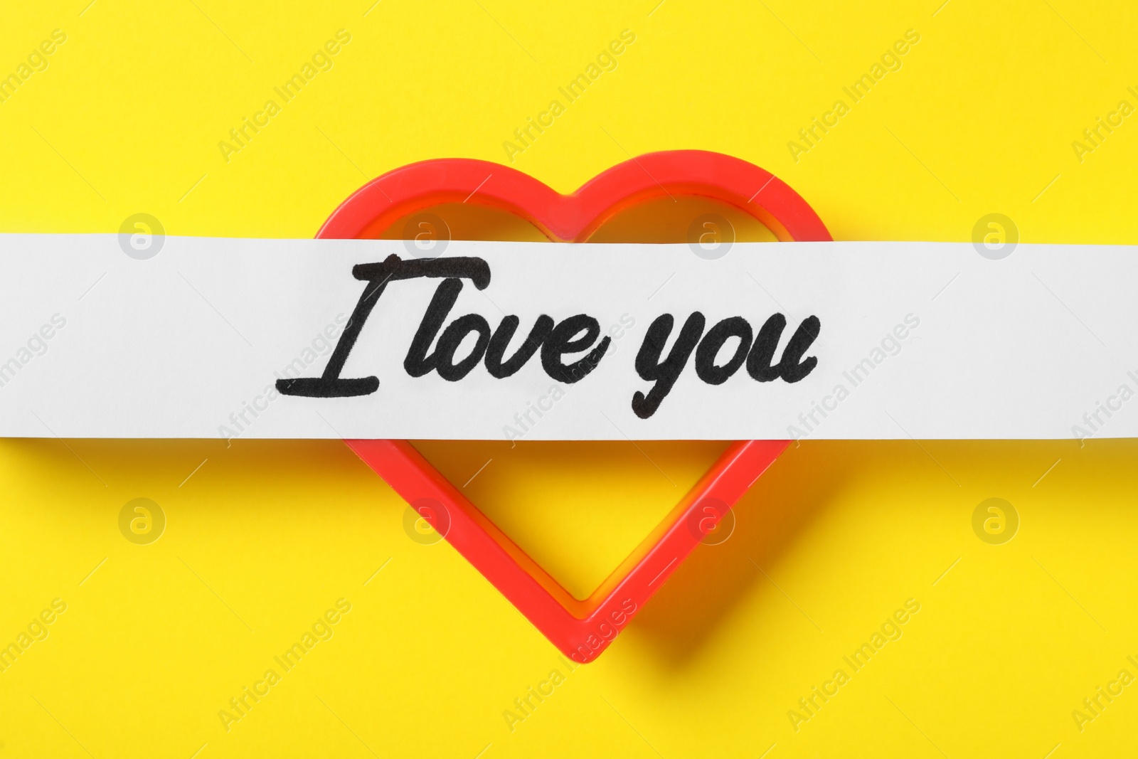 Photo of I Love You message with red heart on yellow background, flat lay