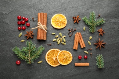 Photo of Flat lay composition with mulled wine ingredients and fir branches on black slate table