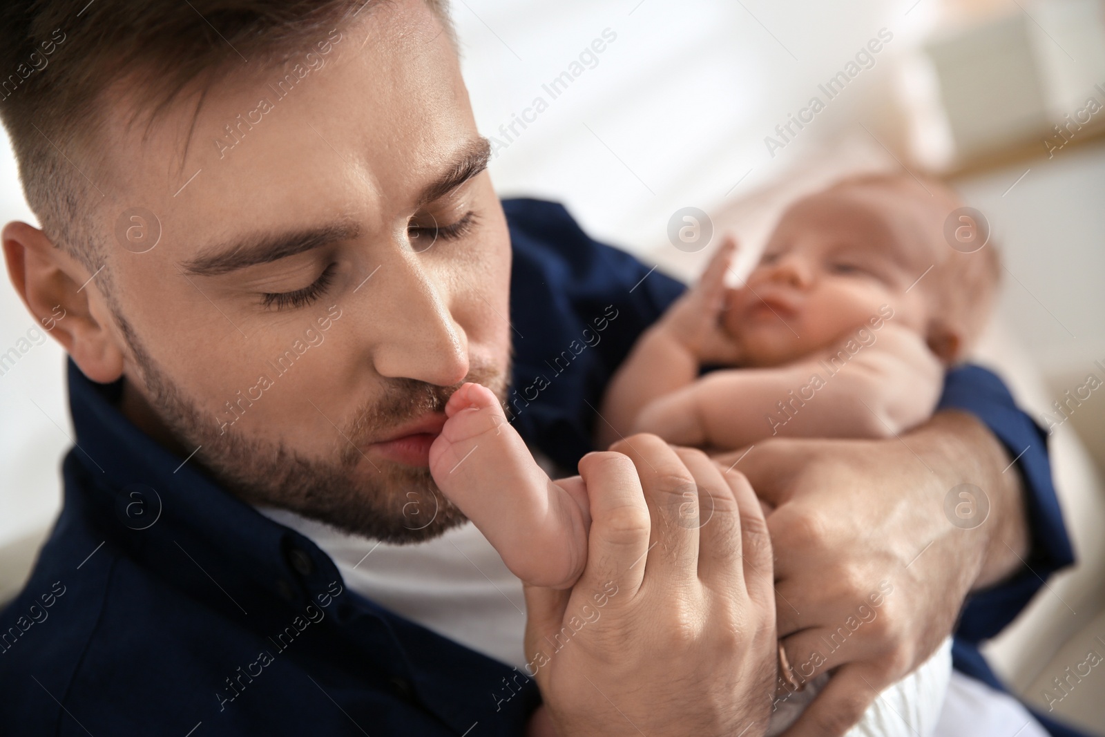 Photo of Father with his newborn son at home