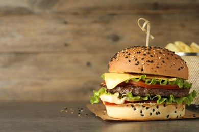 Photo of Burger with delicious patty on gray table, space for text