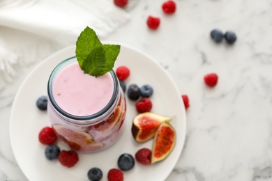 Photo of Delicious fig smoothie in glass jar on white marble table, space for text