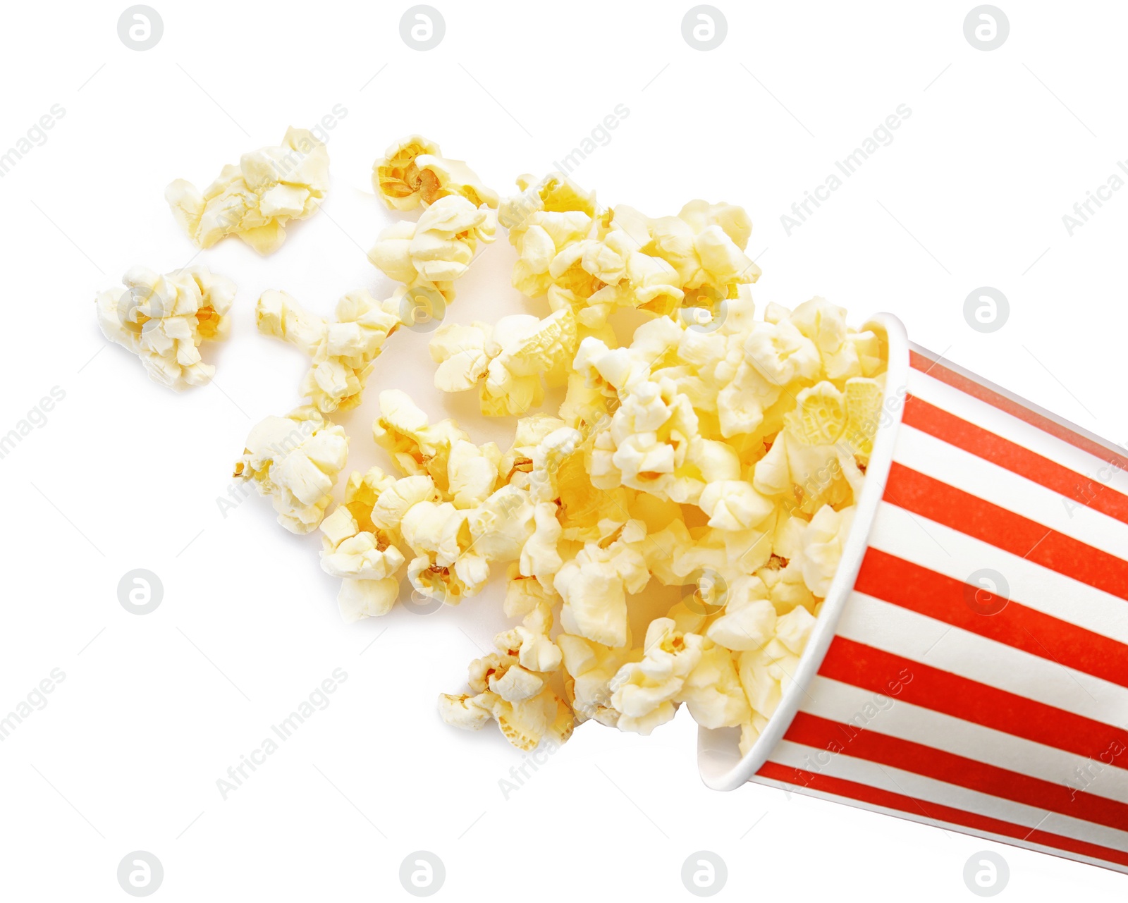 Photo of Overturned cup with delicious fresh popcorn on white background, top view