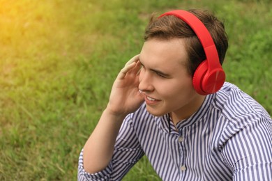 Photo of Handsome young man with headphones outdoors on sunny day
