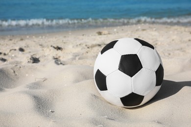 Soccer ball on beach, space for text. Football equipment